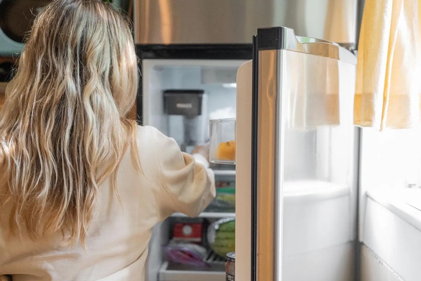 Person taking food from an open refrigerator
