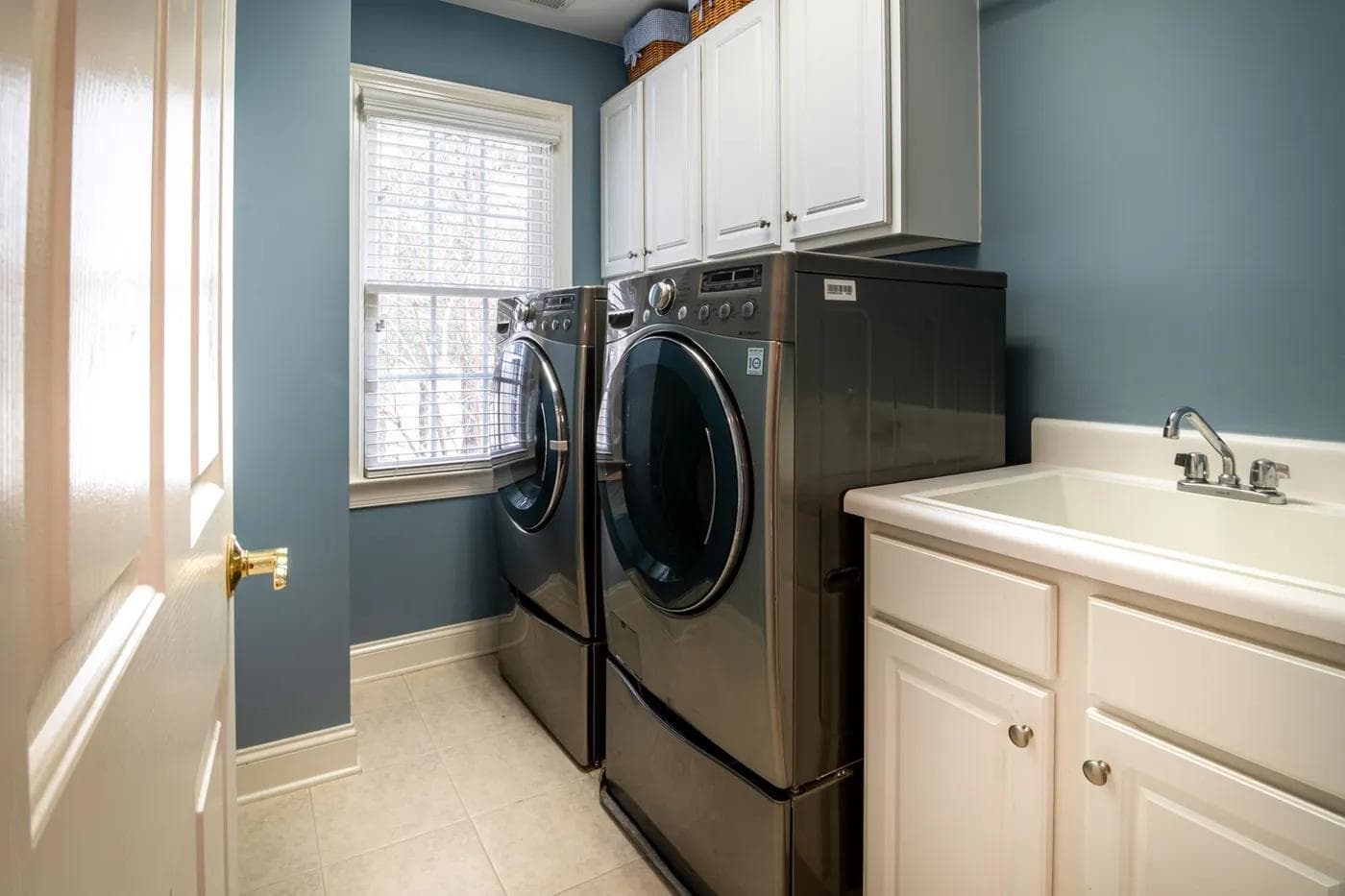 A clean, organized laundry room featuring modern appliances and ample storage